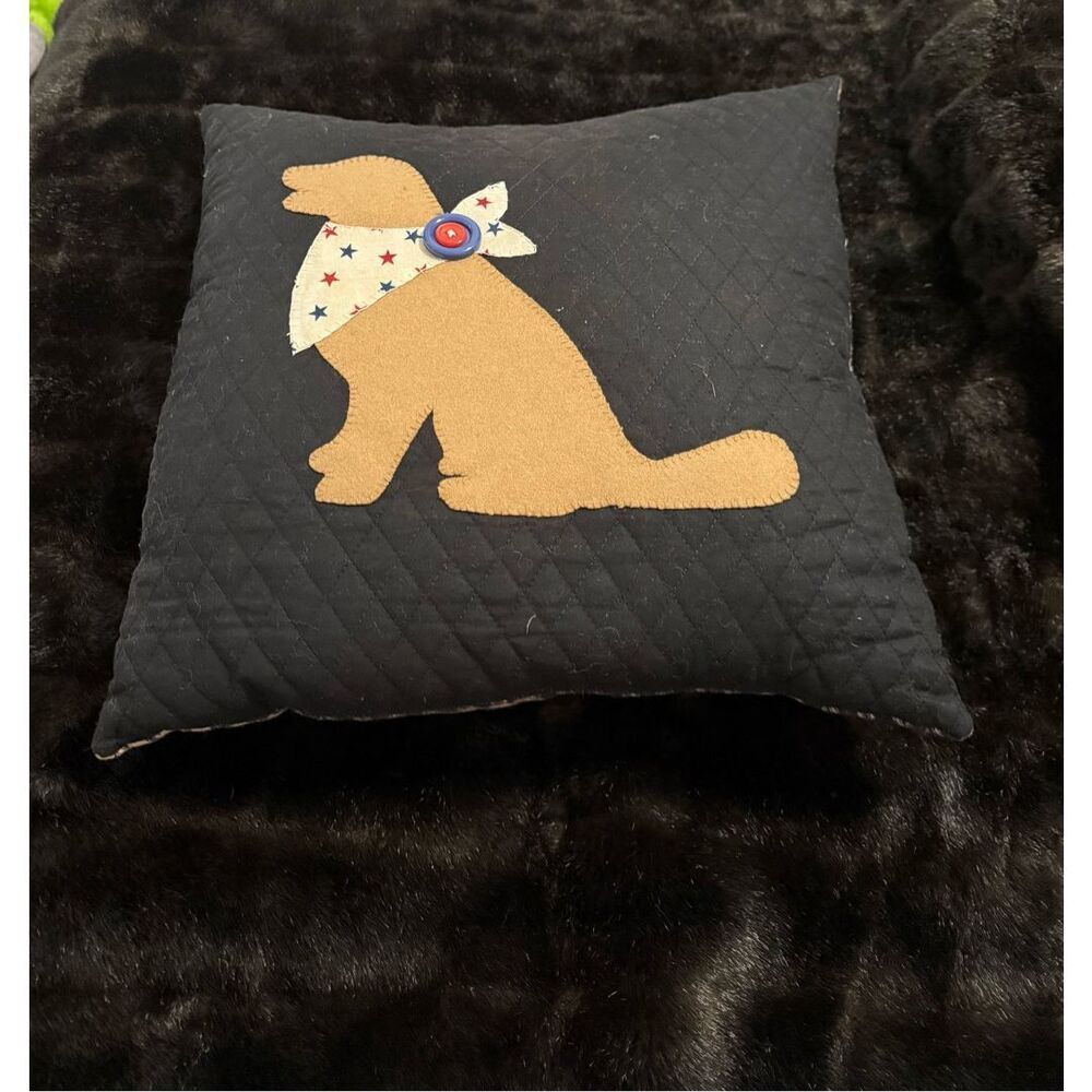 throw pillow‎ featuring a felt appliqué of a dog wearing a bandana.